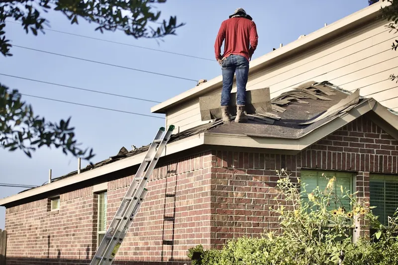 Professional roofer working on a residential roof in Sherman Village